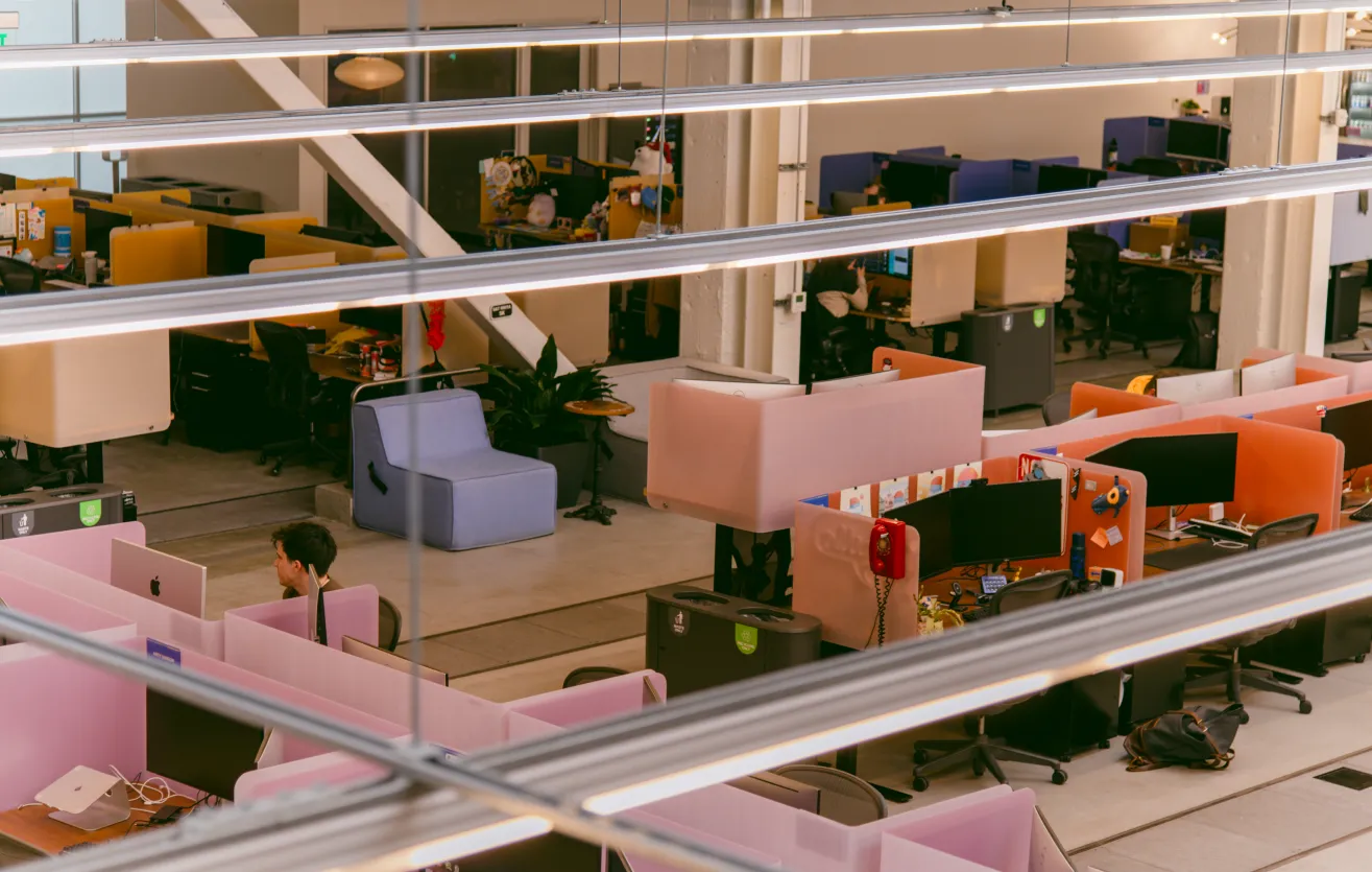 Atlas Meet’s office — a comfortable arrangement of various seating options, computer equipment, individual desks, and Atlas Meet employees at work.