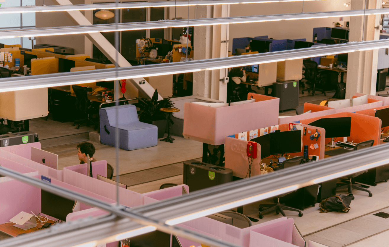 Atlas Meet’s office — a comfortable arrangement of various seating options, computer equipment, individual desks, and Atlas Meet employees at work.